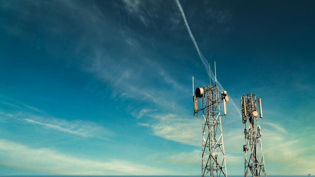Two telecom towers against a blue sky