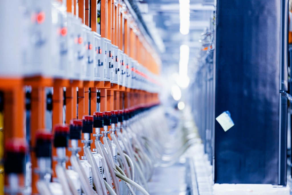 Long row of battery test channels with orange modules and connected cables